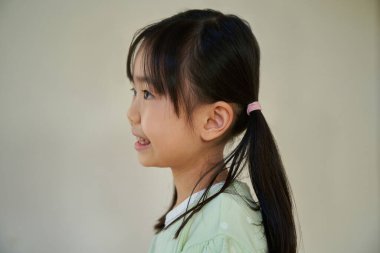 Asyalı gülümseyen ilkokul kızı içerde