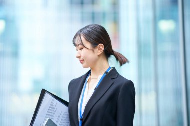 Dışarıdaki takım elbiseli Asyalı genç kadın.