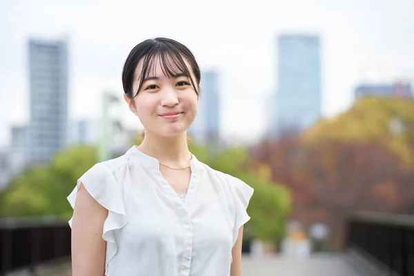 アジアの若い女性が笑顔で屋外に立ち — ストック写真