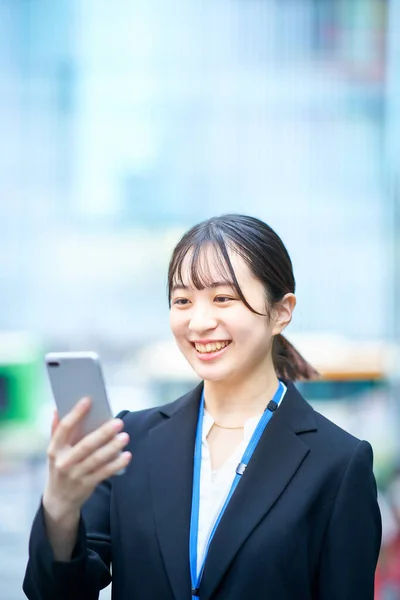 Takım Elbiseli Genç Bir Kadın Akıllı Telefon Ekranına Bakıyor — Stok fotoğraf