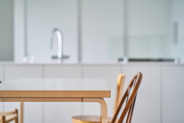 Beyaz ve doğal ahşaba dayalı parlak bir oda.