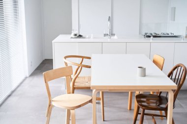 Beyaz ve doğal ahşaba dayalı parlak bir oda.