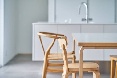 Beyaz ve doğal ahşaba dayalı parlak bir oda.