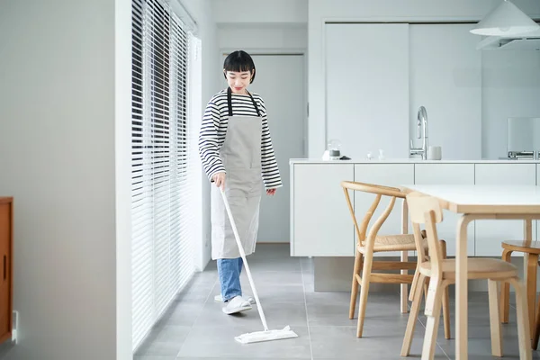 Asian young woman cleaning the floor in the room