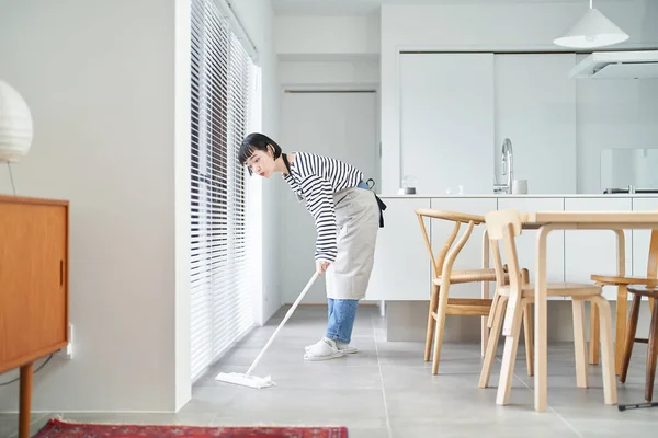 Asian young woman cleaning the floor in the room