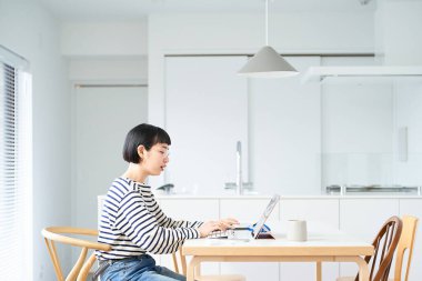 Odada çalışan gözlüklü genç bir kadın.