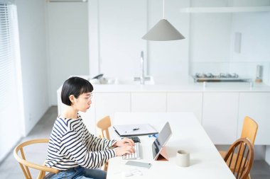 Odada çalışan gözlüklü genç bir kadın.