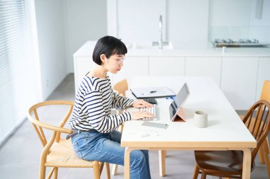 Odada çalışan gözlüklü genç bir kadın.