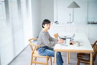 Odada çalışan gözlüklü genç bir kadın.