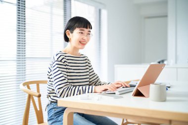 Odada çalışan gözlüklü genç bir kadın.