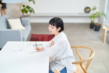 Odaya not defteri yazan genç bir kadın.