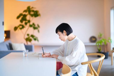 Odaya not defteri yazan genç bir kadın.