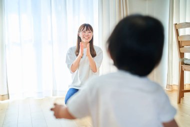 Genç anne ve küçük çocuk odada oynuyorlar.