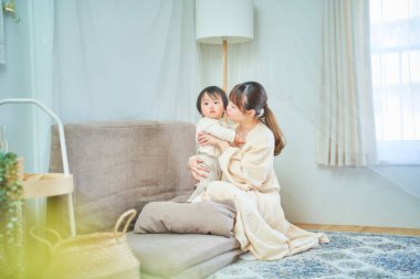 Anne ve çocuk odada sarılıyor.