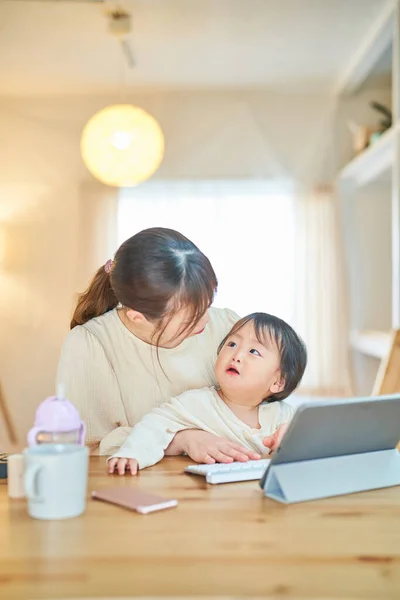 Genç Anne Kucağında Bebekle Bilgisayar Kullanıyor — Stok fotoğraf