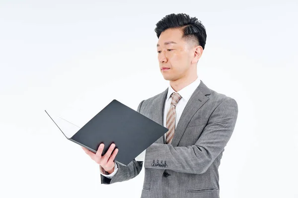 Ein Mann Anzug Blickt Durch Dokumente Und Weißen Hintergrund — Stockfoto