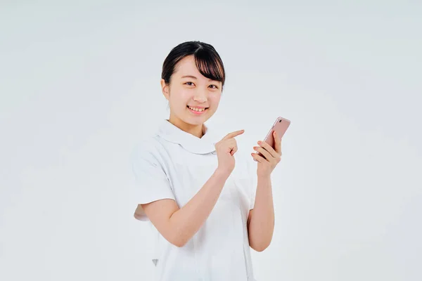 Woman White Coat Operating Smartphone White Background — Stockfoto
