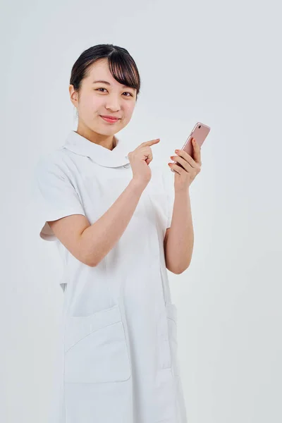 Woman White Coat Operating Smartphone White Background — Stok fotoğraf