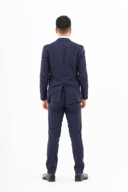 Back view of a man in a suit standing in front of a white background