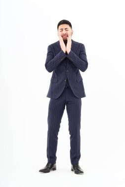 A man in a suit with a sad expression and white background