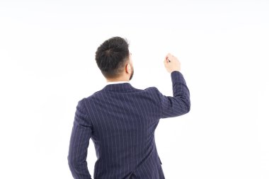 A man in a suit posing to write with a pen and white background
