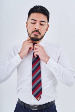 Business man adjusting his tie and white background