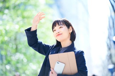 Açık havada gülümseyen genç bir kadının portresi.