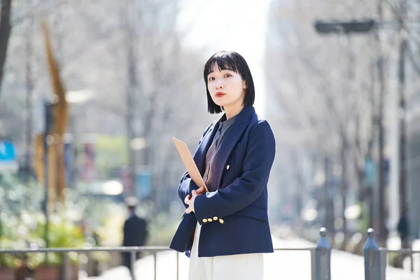 街角に立つオフィスカジュアルなスタイルの若い女性 — ストック写真