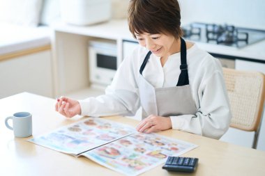 Odadaki market reklamlarına bakan bir kadın.