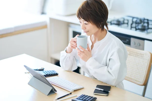 家で働いている間にマグカップを持って休憩する女性 — ストック写真