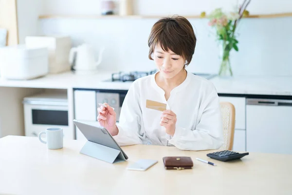 Uma Mulher Segurando Cartão Operando Tablet Sala — Fotografia de Stock