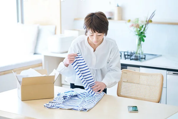 Woman Holding Clothes Table Room — Stock Photo, Image
