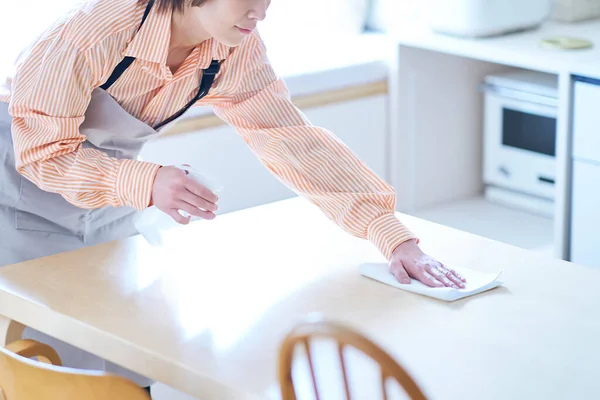 女人擦房间里的餐桌 — 图库照片