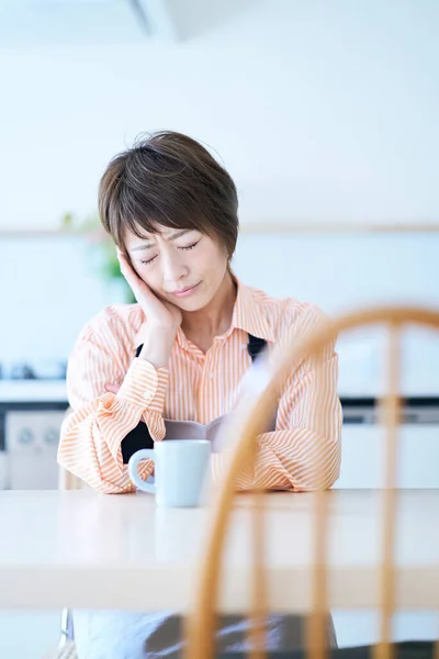 stock image A woman in an apron with a stressed expression in the room                        