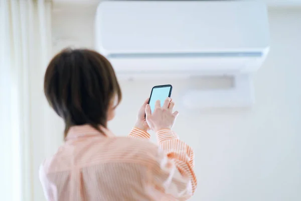 Kvinna Som Håller Smartphone Inomhus — Stockfoto