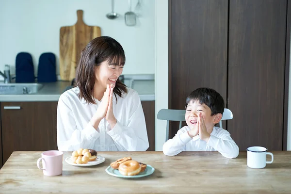 母亲和儿子摆姿势开始在房间里吃饭 — 图库照片