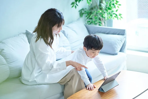 Äiti Lapsi Istuvat Sohvalla Katsovat Tabletin Tietokoneen Näyttöä — kuvapankkivalokuva