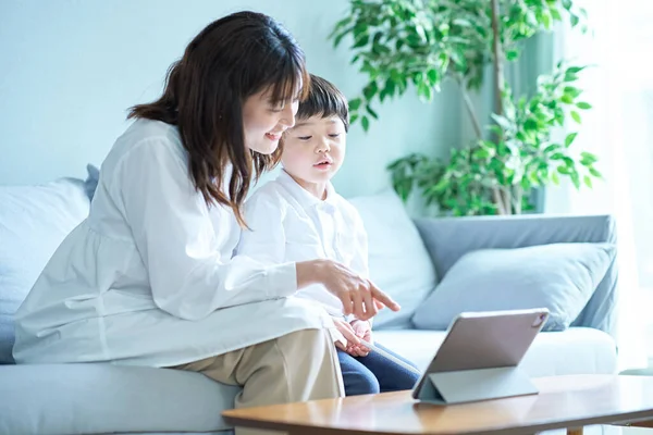 Äiti Lapsi Istuvat Sohvalla Katsovat Tabletin Tietokoneen Näyttöä — kuvapankkivalokuva