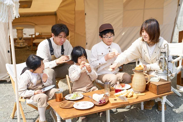 キャンプ場で食事を楽しむ5人家族 — ストック写真