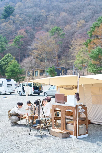 stock image A family setting up a tent at a campsite and relaxing on fine day