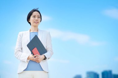 Güzel bir günde dışarıda duran iş kadını.     