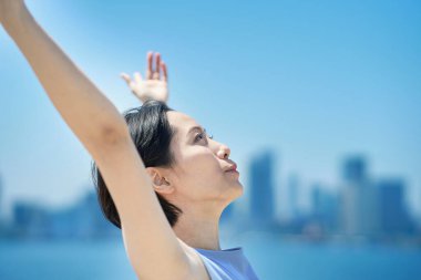 Mavi gökyüzünün altında gevşek bir yüzü olan bir kadın.