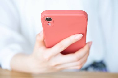 Akıllı telefon kullanan bir kadının eli.