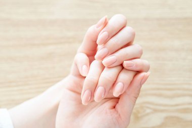 A woman's hand checking the condition of her nails                 clipart