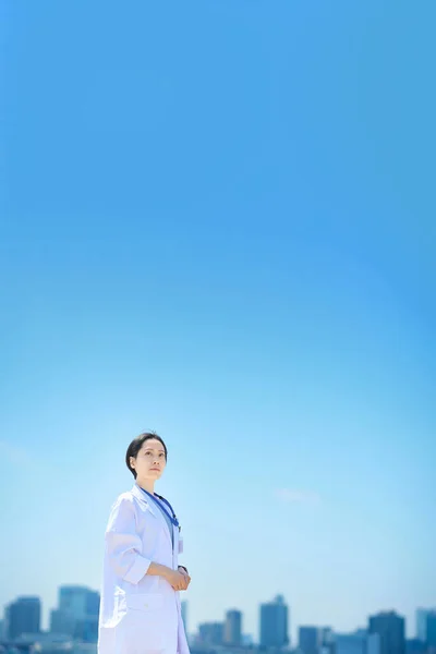 Een Vrouw Een Witte Jas Een Zonnige Skyline — Stockfoto
