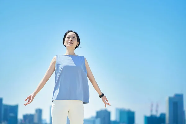 Una Mujer Con Una Expresión Relajada Bajo Cielo Azul —  Fotos de Stock