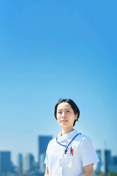 Eine Frau Weißen Mantel Steht Vor Einem Sonnigen Stadtbild — Stockfoto