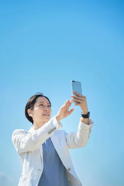 Azji Kobieta Trzyma Smartfon Zewnątrz — Zdjęcie stockowe