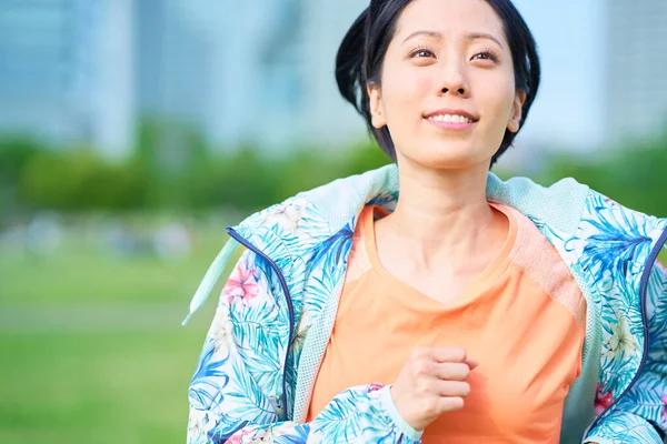 stock image Asian woman running on urban green space