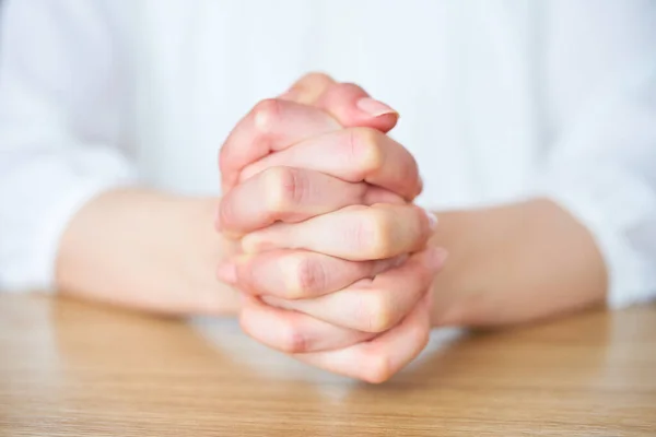 stock image Hands of a woman who thinks with her hands folded in the room